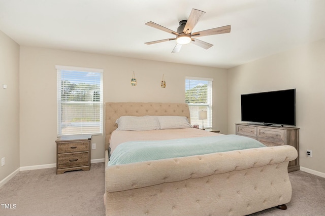 bedroom with multiple windows, light carpet, and ceiling fan