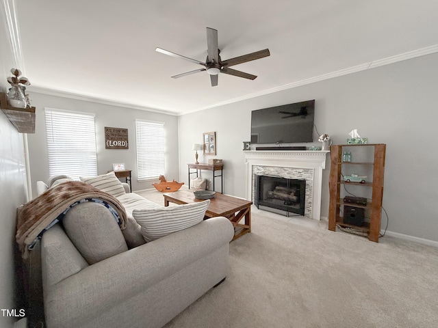 carpeted living room featuring a high end fireplace, ornamental molding, and ceiling fan