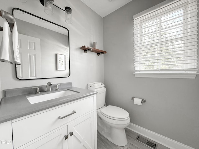 bathroom with vanity, toilet, and wood-type flooring