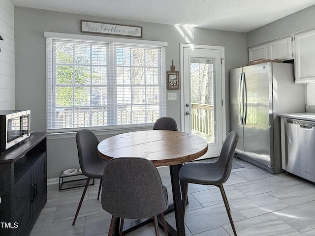 dining area with plenty of natural light and a textured ceiling