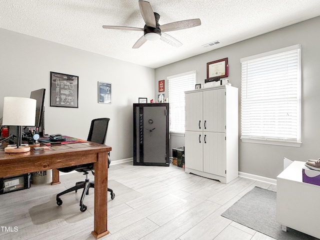 home office with ceiling fan, a textured ceiling, and light wood-type flooring