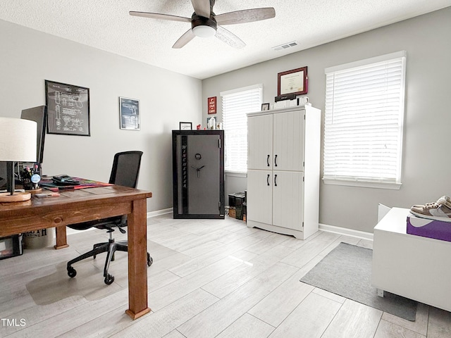 office space with a textured ceiling, ceiling fan, and light hardwood / wood-style floors