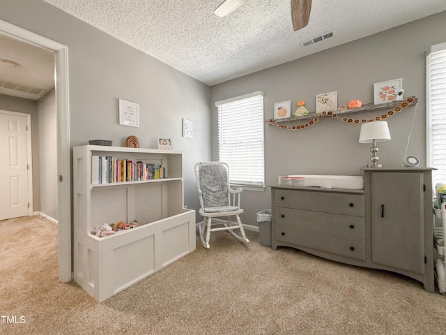 sitting room with carpet floors, a textured ceiling, and ceiling fan