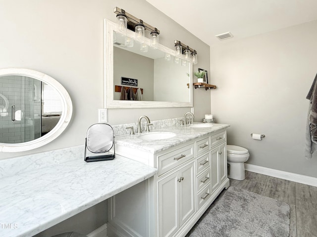 bathroom featuring vanity, hardwood / wood-style floors, walk in shower, and toilet