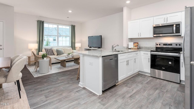 kitchen with white cabinetry, appliances with stainless steel finishes, and kitchen peninsula