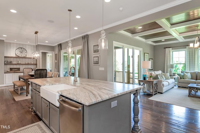 kitchen with a center island with sink, stainless steel dishwasher, and decorative light fixtures