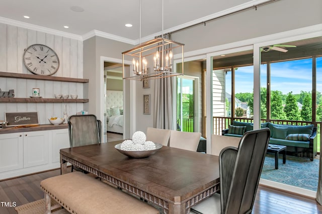 dining area featuring crown molding, dark hardwood / wood-style floors, and an inviting chandelier