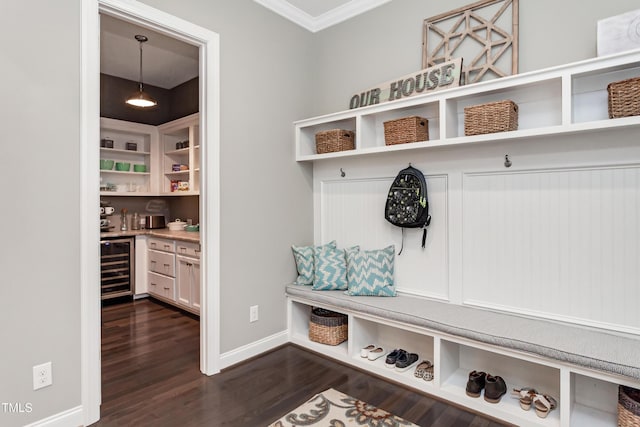 mudroom with bar, dark wood-type flooring, ornamental molding, and beverage cooler