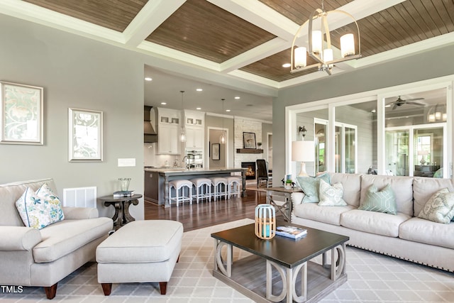 living room featuring coffered ceiling, crown molding, light wood-type flooring, wooden ceiling, and beam ceiling