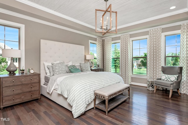 bedroom featuring ornamental molding, dark hardwood / wood-style floors, a chandelier, and a tray ceiling