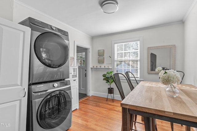 washroom with stacked washer and dryer, ornamental molding, and light hardwood / wood-style flooring