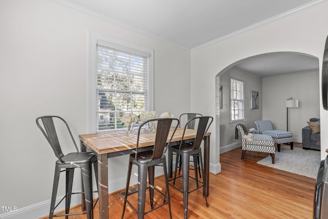 dining area with crown molding and light hardwood / wood-style flooring