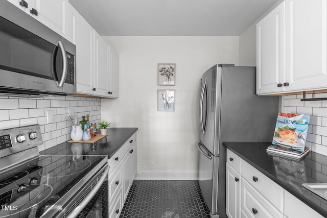 kitchen featuring stainless steel appliances, dark tile patterned floors, white cabinets, and decorative backsplash