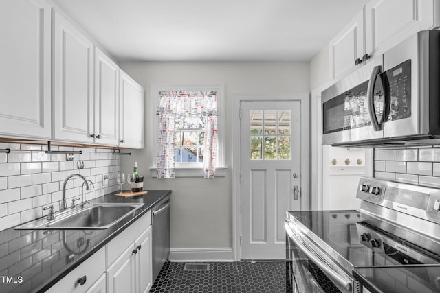 kitchen with stainless steel appliances, sink, and white cabinets