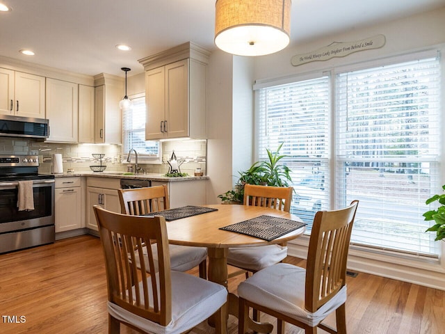 dining area with sink and light hardwood / wood-style floors