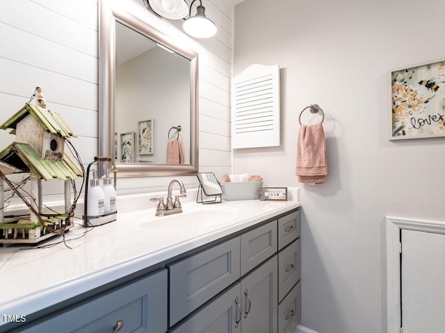 bathroom featuring vanity and wooden walls