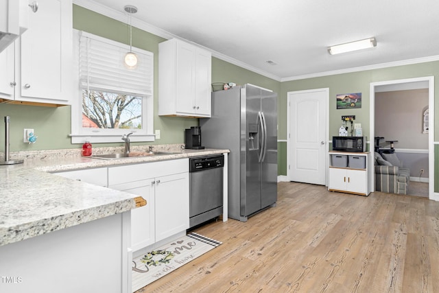 kitchen featuring stainless steel appliances, ornamental molding, a sink, and white cabinetry