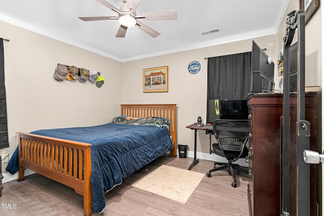 bedroom with baseboards, visible vents, a ceiling fan, ornamental molding, and wood finished floors