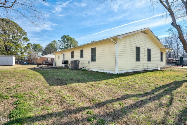 back of house with a lawn and central AC