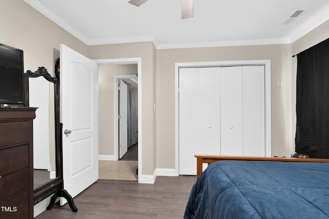 bedroom with visible vents, crown molding, and wood finished floors