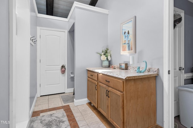 bathroom featuring tile patterned flooring, baseboards, and vanity