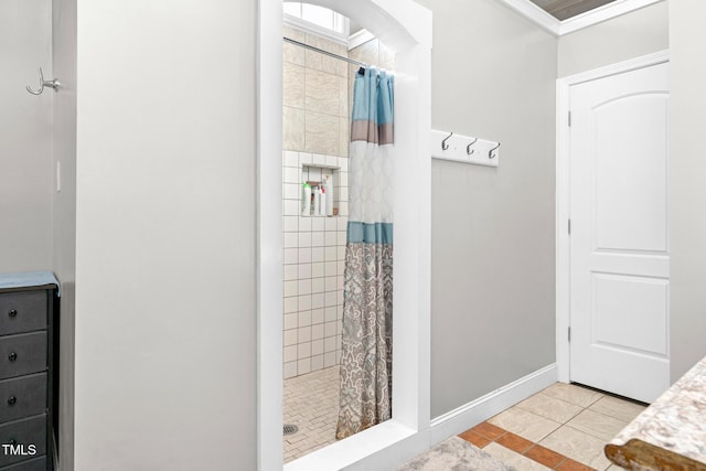 bathroom with a shower stall, baseboards, and tile patterned floors