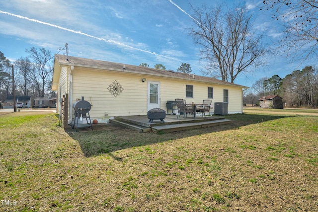 back of property featuring central AC unit and a yard