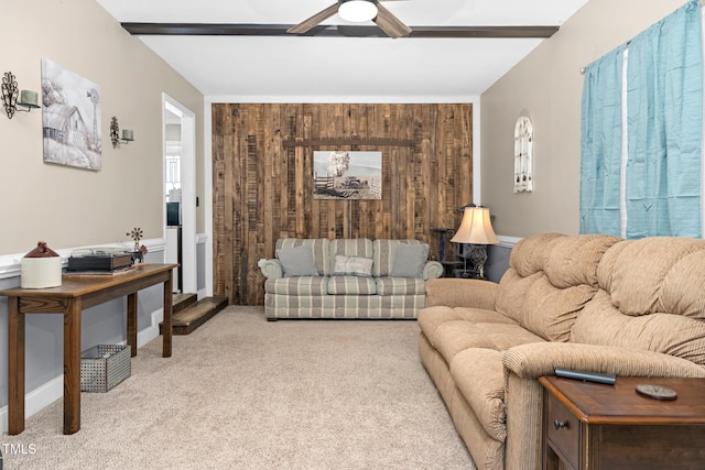 living area featuring ceiling fan, wooden walls, and light colored carpet