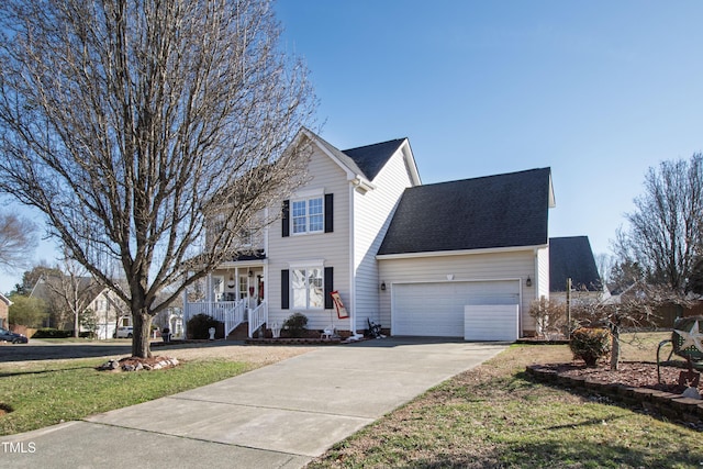 traditional home with a garage, driveway, roof with shingles, and a front yard