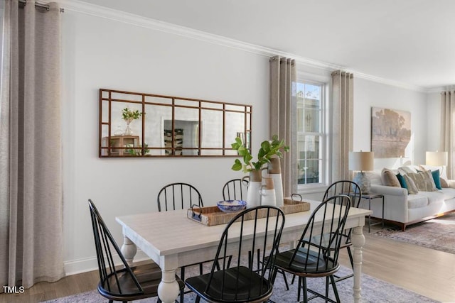 dining area featuring wood-type flooring and ornamental molding