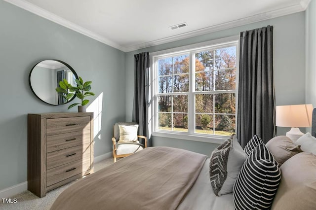 bedroom with ornamental molding and light colored carpet