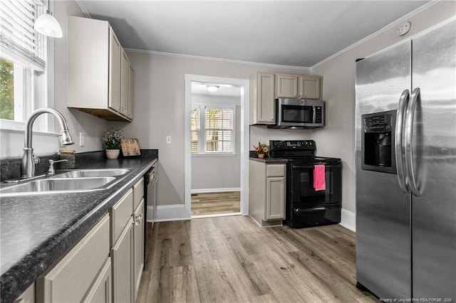 kitchen featuring sink, crown molding, pendant lighting, light hardwood / wood-style floors, and black appliances