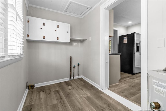 laundry area with crown molding, wood-type flooring, and a healthy amount of sunlight