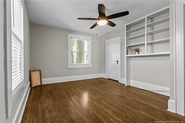 interior space with ceiling fan and dark hardwood / wood-style flooring