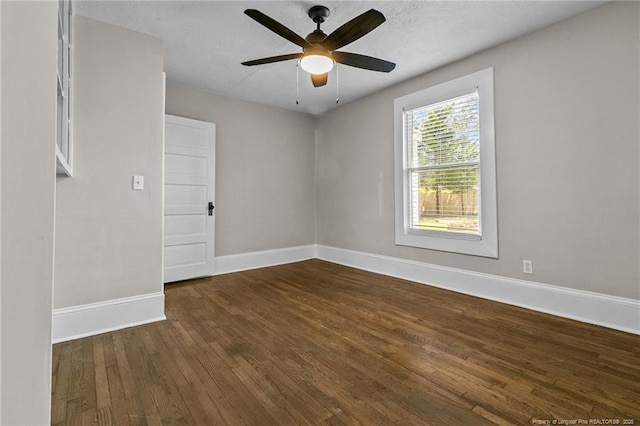 empty room featuring ceiling fan, dark hardwood / wood-style flooring, and a textured ceiling