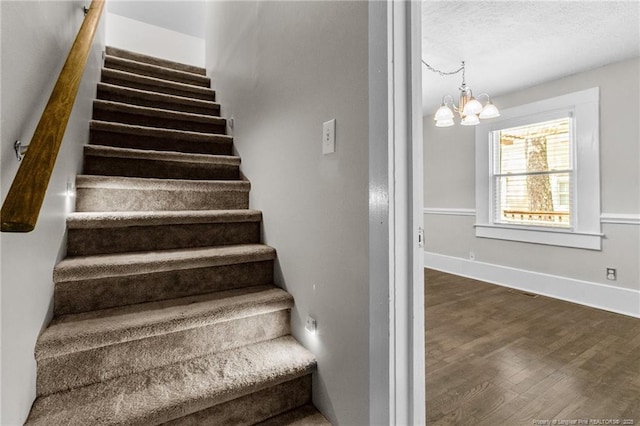 stairs featuring a notable chandelier and hardwood / wood-style flooring