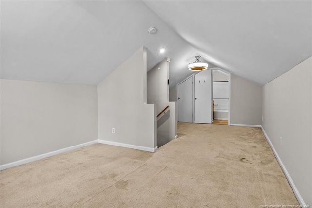 additional living space with vaulted ceiling and light carpet