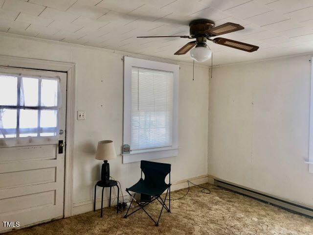 doorway featuring baseboards, ceiling fan, and baseboard heating