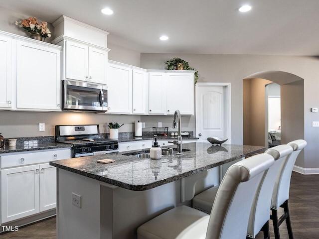 kitchen featuring white cabinetry, appliances with stainless steel finishes, sink, and a center island with sink