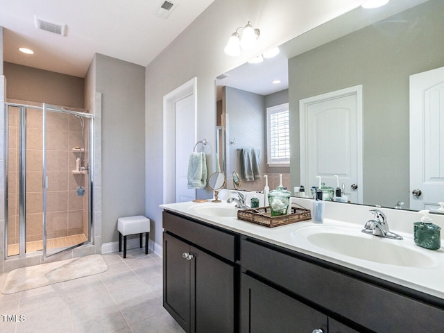 bathroom with vanity, a shower with shower door, and tile patterned floors