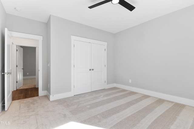 unfurnished bedroom with light colored carpet, a closet, and ceiling fan