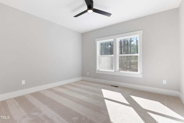 spare room featuring ceiling fan and light colored carpet