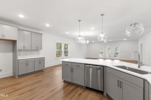 kitchen with gray cabinets, pendant lighting, dishwasher, sink, and backsplash