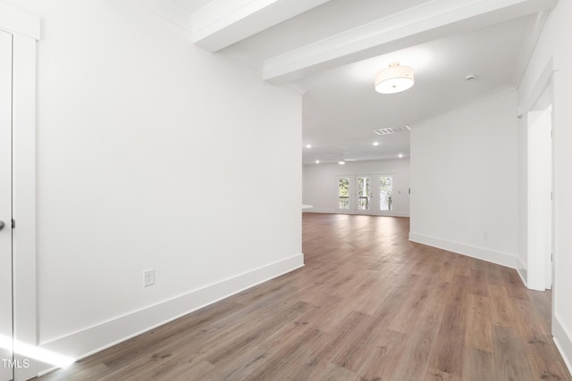 spare room with crown molding, light hardwood / wood-style floors, french doors, and beamed ceiling