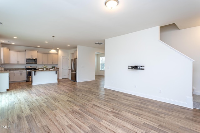 unfurnished living room with sink and light wood-type flooring