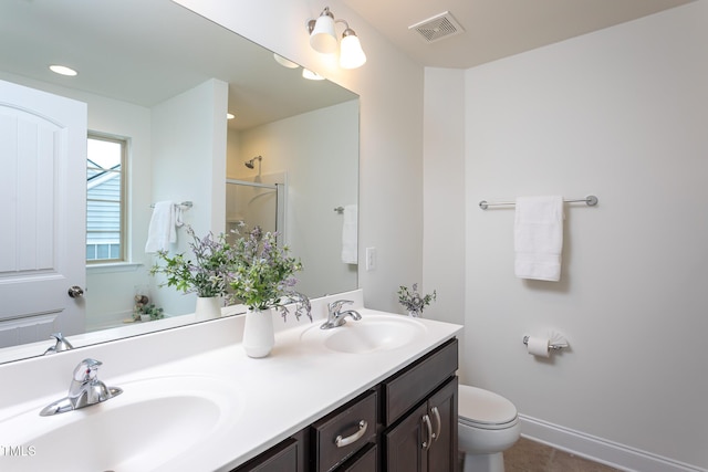 bathroom with vanity, toilet, and walk in shower