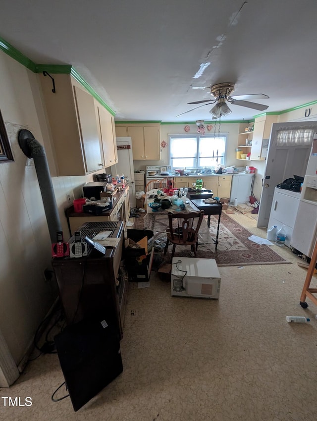 kitchen featuring ceiling fan, white fridge, and cream cabinetry