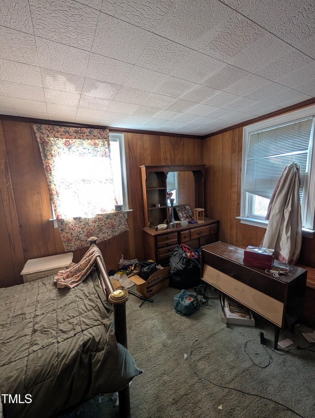 bedroom with carpet and wood walls