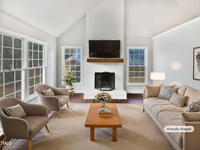 living room with high vaulted ceiling, a fireplace, and hardwood / wood-style floors