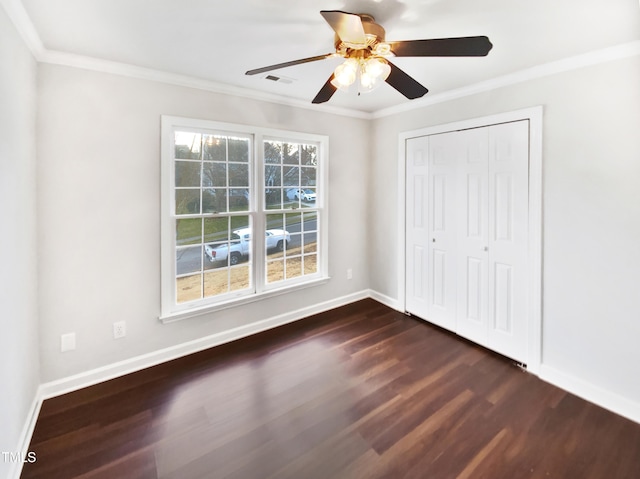 unfurnished bedroom with ceiling fan, ornamental molding, dark hardwood / wood-style floors, and a closet